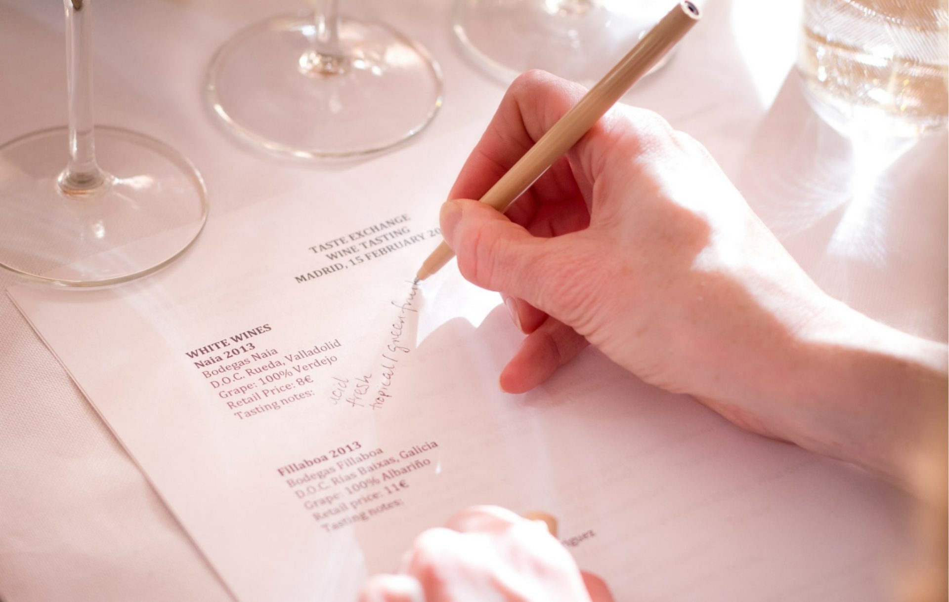 hand with pencil writing on tasting menu